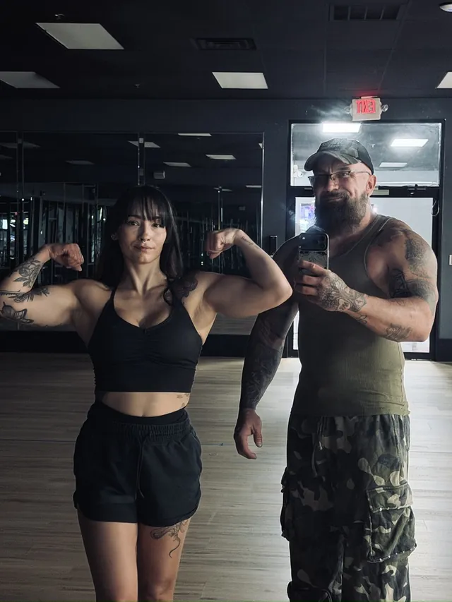 Shannon Cain and his wife in the gym mirror